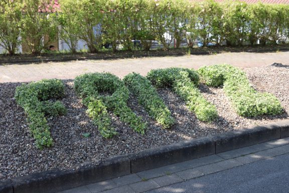 Fritz Reuter Pflegedienst GmbH Der Schriftzug "Fritz" aus Pflanzen in einem Garten.